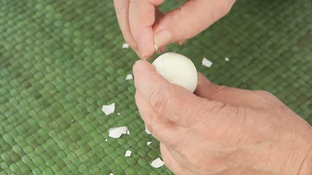 男は調理された卵を系統的に皮をむく - 映像、動画
