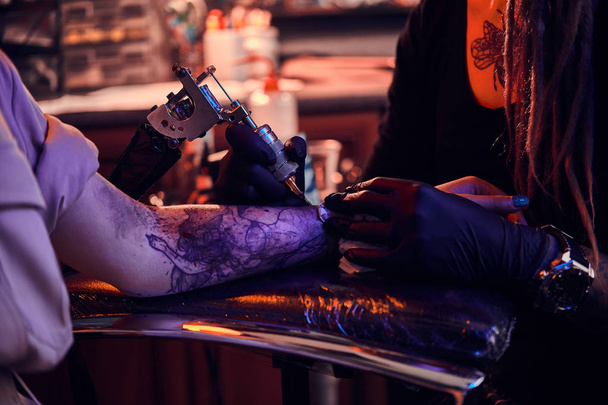 Processo di tatuaggio che fa a studio scuro del tatuaggio
. - Foto, immagini