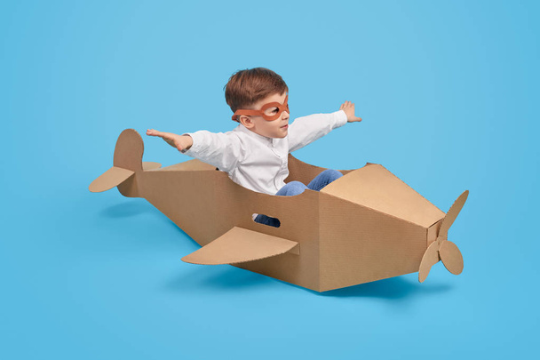 Little aviator flying in carton plane - Фото, зображення