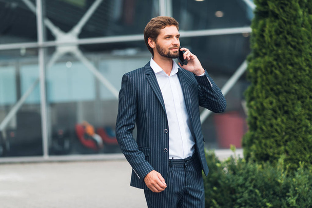 Handsome man in suit using smartphone - Zdjęcie, obraz