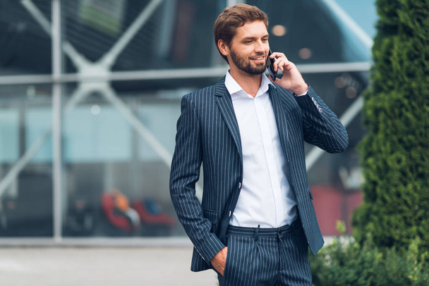 Handsome man in suit using smartphone - Photo, image