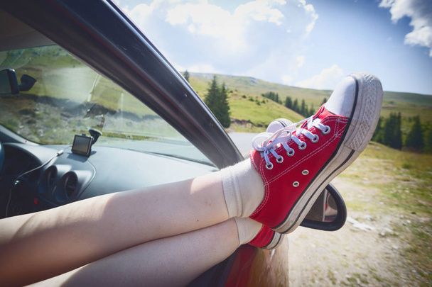 Girl legs sticking out of the car  - Фото, изображение