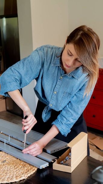 mujer con destornillador instalando un mueble en casa personalmente
 - Foto, imagen