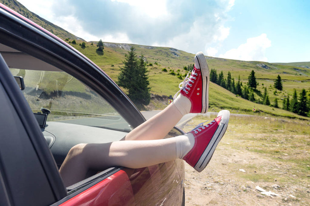 Girl legs sticking out of the car  - Foto, afbeelding
