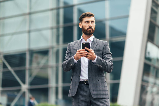 Businessman texting messages while walking - Foto, Bild