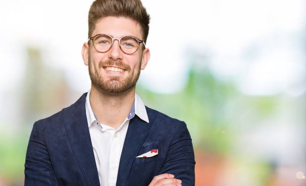 Young handsome business man wearing glasses happy face smiling with crossed arms looking at the camera. Positive person. - Photo, image
