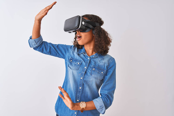 Jonge African American tiener meisje spelen virtual reality spel met behulp van bril - Foto, afbeelding