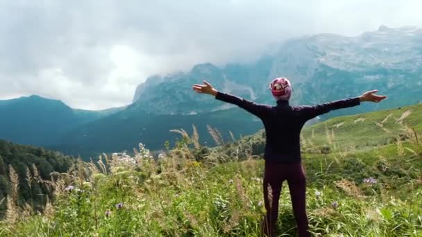 Donna escursionista alza le mani in montagna godendo di una splendida vista e la natura selvaggia circostante. Vittoria e successo, il raggiungimento dell'obiettivo
. - Filmati, video