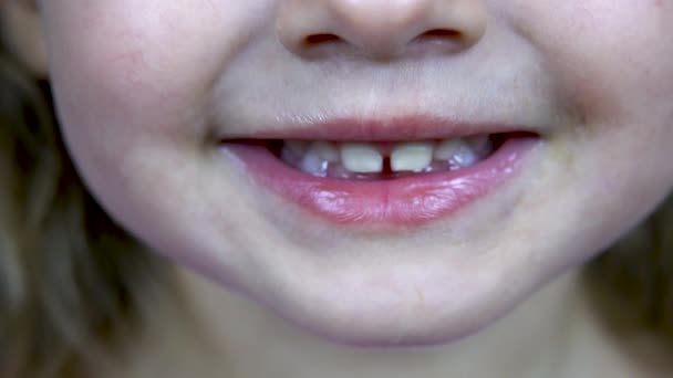 Kahden vuoden ikäinen tyttö näyttää hampaansa. Lähemmäs. 4 k.
 - Materiaali, video