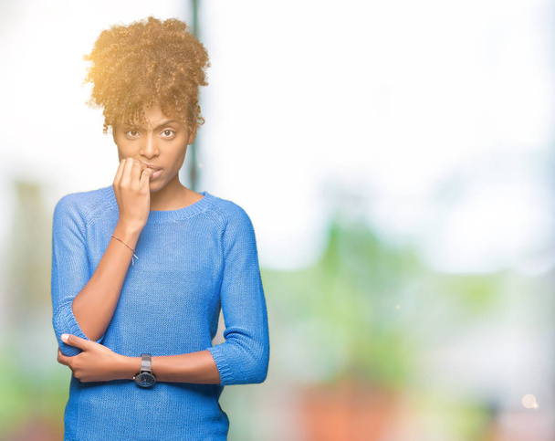 Beautiful young african american woman over isolated background looking stressed and nervous with hands on mouth biting nails. Anxiety problem. - Photo, Image