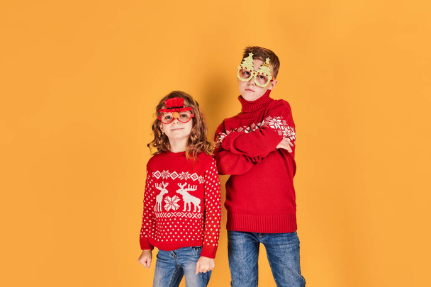Children in warm red Christmas sweaters - Fotografie, Obrázek