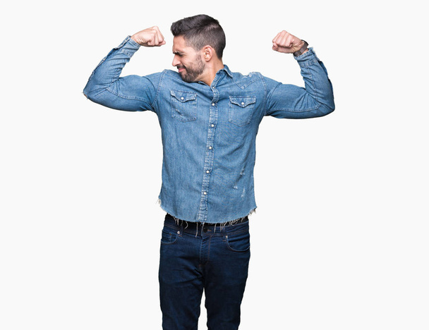 Mladý pohledný muž izolované pozadí ukazuje svaly paže s úsměvem hrdá. Fitness koncept. - Fotografie, Obrázek