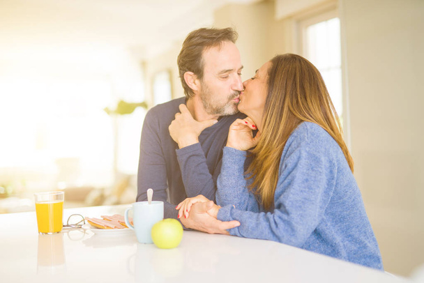 Beautiful romantic middle age couple kissing having healthy breaskfast in the morning at home - Φωτογραφία, εικόνα