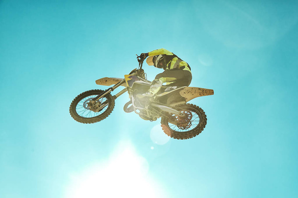 Versenyző a motorkerékpár Dirtbike motocross Cross-Country repülés, ugrások és leveszi a ugródeszka ég ellen. Koncepció aktív extrém pihenés. - Fotó, kép