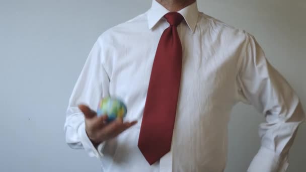 Человек в галстуке красного цвета бросает глобус - будущее нашей планеты в руках политиков
 - Кадры, видео