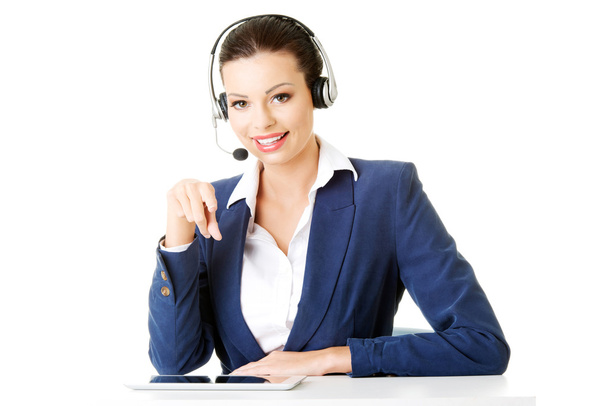 Beautiful young call-center assistant at the desk - Foto, Imagen