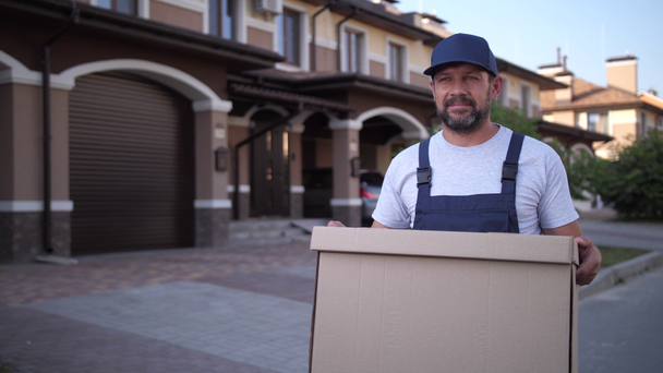 Employee of delivery service carrying box outdoors - Imágenes, Vídeo