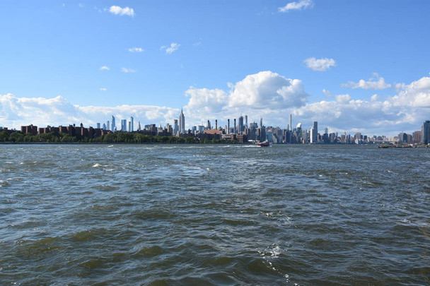 NEW YORK CITY - 30 GIUGNO: Veduta di Manhattan, New York, dal Domino Park di Brooklyn, come visto il 30 giugno 2019. New York è la città più grande per popolazione negli Stati Uniti e ha milioni di visitatori all'anno
. - Foto, immagini