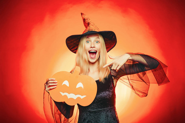 Happy Halloween. Glamour Fashion Sexy Vampire Lady with witch costume. Carved Pumpkin - funny concept. - Zdjęcie, obraz