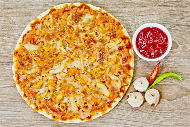 Klasyczna Pizza z owocami morza z pikantnym sosem chilli. - Zdjęcie, obraz
