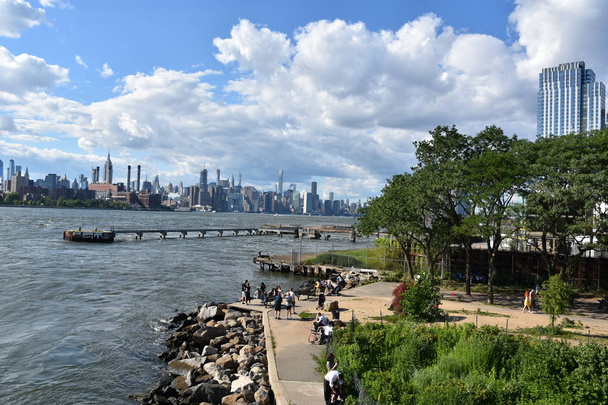 Бруклин, Нью-Йорк - 30 июня 2019 года: Вид на Манхэттен из Domino Park в Бруклине, штат Нью-Йорк. - Фото, изображение