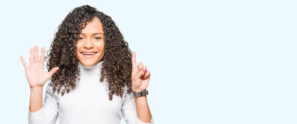 Young beautiful woman with curly hair wearing turtleneck sweater showing and pointing up with fingers number six while smiling confident and happy. - Photo, Image