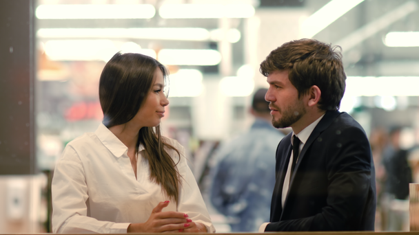 Üzleti partnerek vidám férfi és a nő beszél kávézóban egy bevásárlóközpontban. - Felvétel, videó