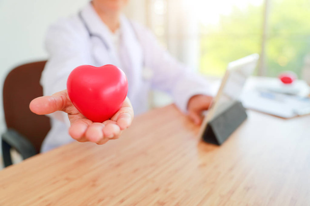 Arzt hält und gibt ein rotes Herz der Liebe und Fürsorge (dieses ima - Foto, Bild