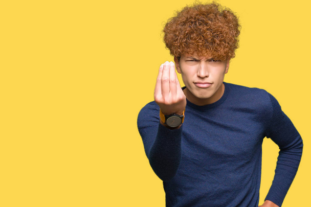junger gutaussehender Mann mit Afro-Haaren macht italienische Geste mit selbstbewusstem Ausdruck an der Hand und den Fingern - Foto, Bild