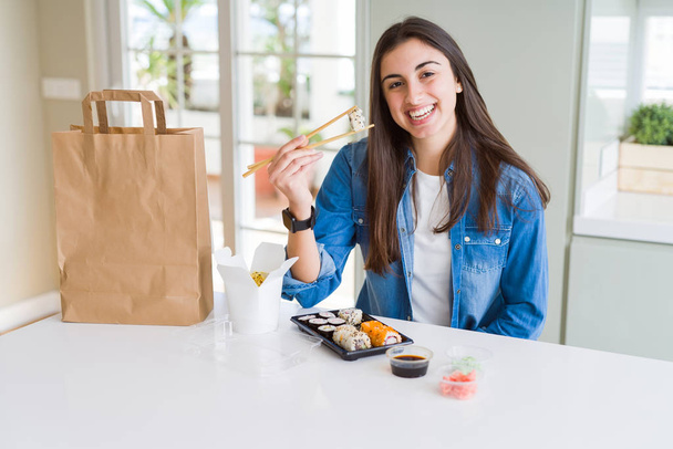 Jeune femme manger sushi asiatique nourriture et nouilles à l'aide de baguette
 - Photo, image