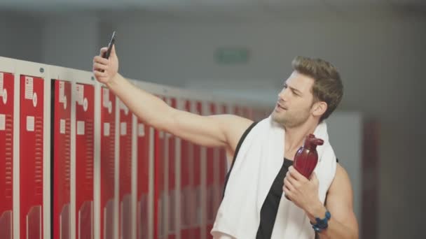 Hombre sonriente tomando fotos móviles después del entrenamiento de fitness
. - Metraje, vídeo