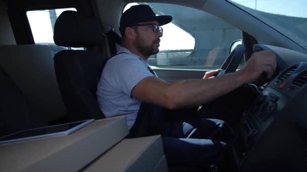 Selbstbewusster Zusteller fährt Auto durch die Stadt - Filmmaterial, Video