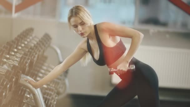 Blonde Sportlerin trainiert Trizeps im Sportverein. - Filmmaterial, Video