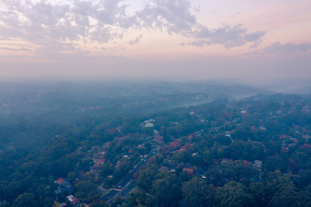 Αγροτικές πυροσβεστικών υπηρεσιών (RFS) τα εγκαύματα μείωσης κινδύνου δημιουργούν καπνό και ομίχλη πάνω από τη λεκάνη του Σίδνεϊ, μειώνοντας την ορατότητα και αυξάνοντας τον κίνδυνο άσθματος και αναπνευστικά προβλήματα - Φωτογραφία, εικόνα
