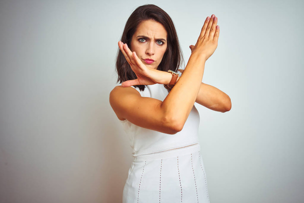 Молодая красивая женщина в платье стоя на белом изолированном фоне Отказ выражение лица скрещивание рук делает негативный знак, сердитый лицо
 - Фото, изображение