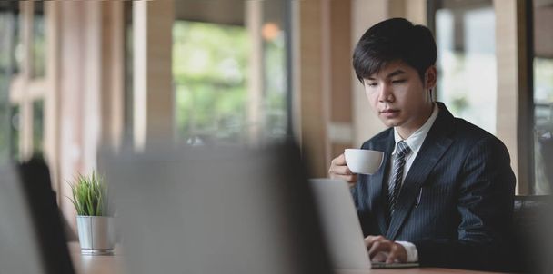 Молодой профессиональный бизнесмен пьет чашку кофе
 - Фото, изображение