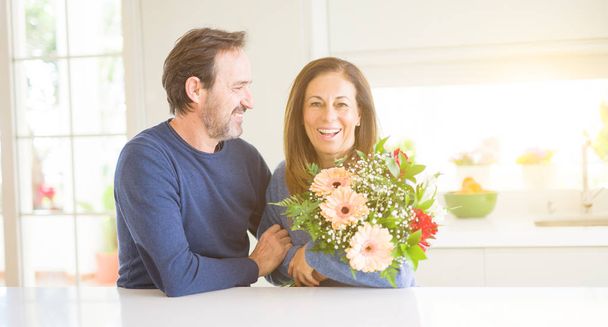 Романтическая пара средних лет с влюбленными цветами дома
 - Фото, изображение
