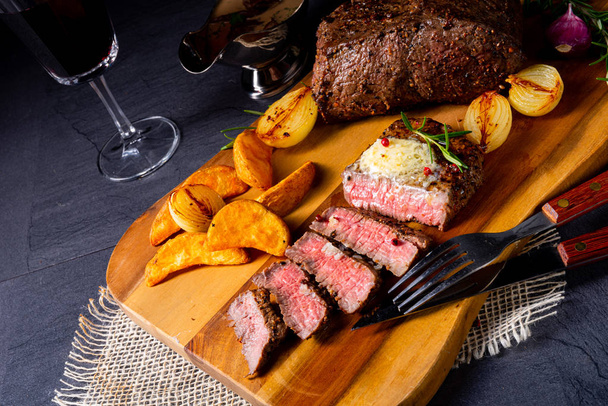 rustic medium butter beef steak with herbs and potato wedges - Fotó, kép