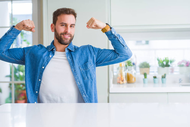 Handsome man at home showing arms muscles smiling proud. Fitness concept. - Fotoğraf, Görsel