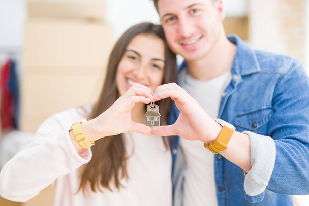 Bonito jovem casal abraçando no amor e mostrando as chaves da nova casa, sorrindo feliz se mudando para um novo apartamento
 - Foto, Imagem