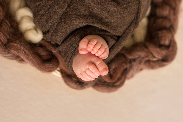Füße des Neugeborenen, Finger am Fuß, mütterliche Pflege, Liebe und Umarmungen in der Familie, Zärtlichkeit - Foto, Bild