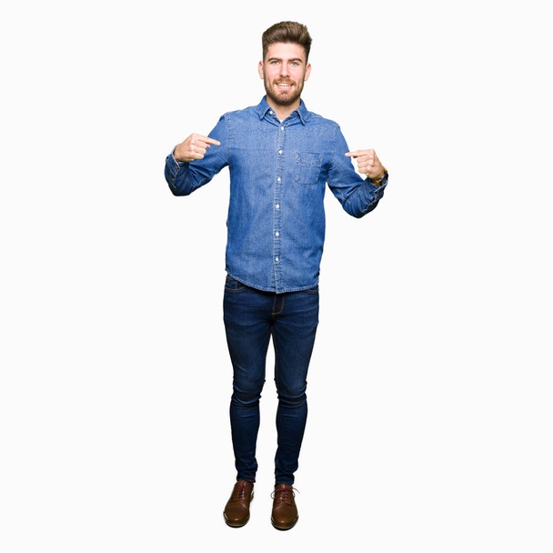 Young handsome blond man wearing casual denim shirt looking confident with smile on face, pointing oneself with fingers proud and happy. - Foto, imagen