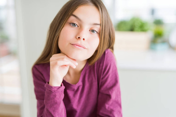 Beautiful young girl kid with hand on chin thinking about question, pensive expression. Smiling with thoughtful face. Doubt concept. - Foto, Imagem