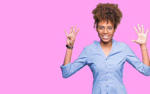 孤立した背景表示と指で上向きに美しい若いアフリカ系アメリカ人ビジネス女性ナンバー ナイン自信を持って、幸せな笑みを浮かべて、. - 写真・画像