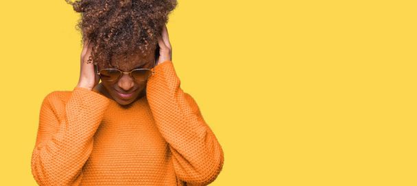 Belle jeune femme afro-américaine portant des lunettes de soleil sur fond isolé souffrant de maux de tête désespérés et stressés parce que la douleur et la migraine. Mains sur la tête
. - Photo, image