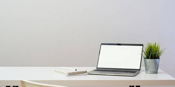Local de trabalho simples com computador portátil de tela em branco aberto e deco
 - Foto, Imagem