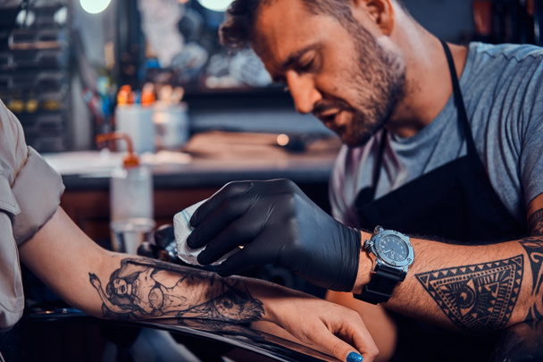 Δάσκαλος τατουάζ δημιουργεί νέο τατουάζ για τον πελάτη - Φωτογραφία, εικόνα