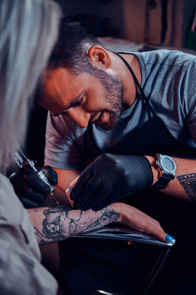 Tattoo Master creëert nieuwe tattoo voor de klant - Foto, afbeelding