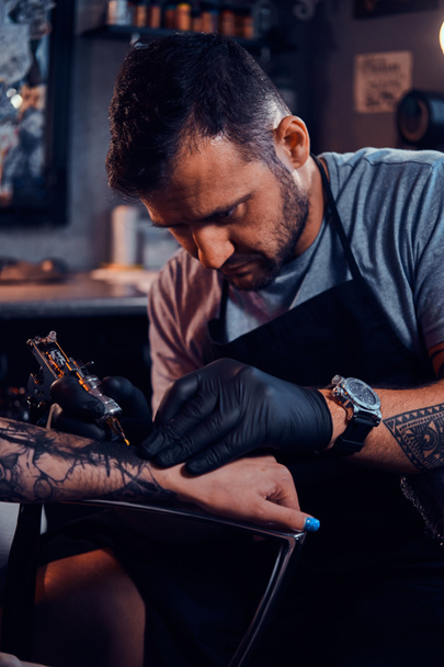 Майстер татуювання створює нове татуювання для клієнта
 - Фото, зображення