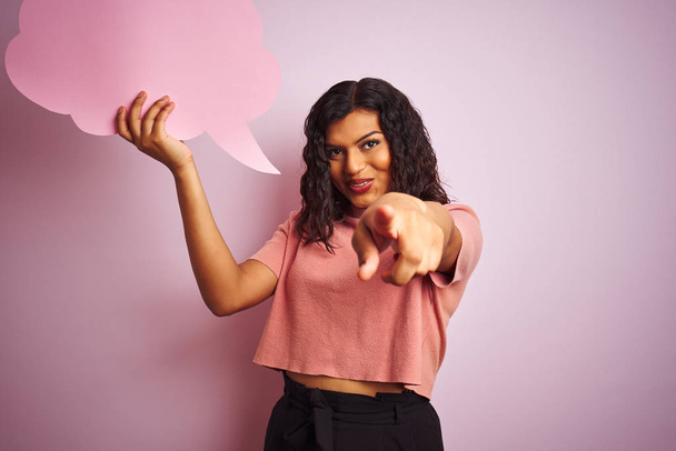 Transsexuel transgenre femme tenant parole bulle nuage sur fond rose isolé pointant avec le doigt à la caméra et à vous, signe de la main, geste positif et confiant de l'avant
 - Photo, image